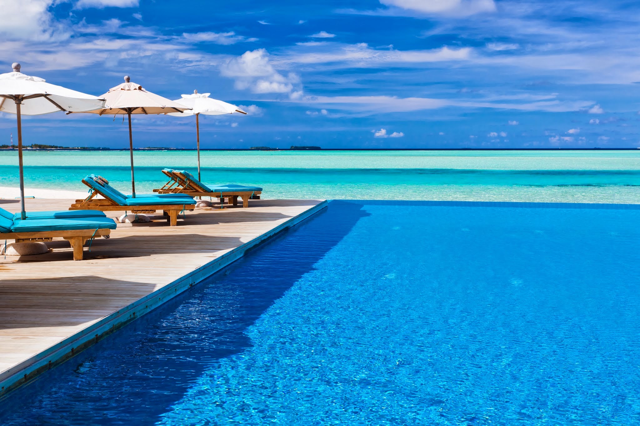 Deck chairs and infinity pool over amazing tropical lagoon